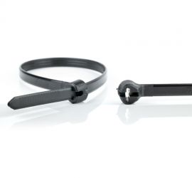 Een zwarte Ty-Rap® polypropyleen kabelbinder, UV bestendig, naast een uitvergrote sluiting van een andere zwarte Ty-Rap® polypropyleen kabelbinder.