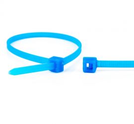 Een Tefzel kunststof kabelbinder, chemisch bestendig, naast een uitvergrote sluiting van een andere kabelbinder.