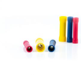 Two red, two yellow and two blue insulated butt connectors, three standing upright and three lying down, on a white background.