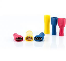 Two red, two yellow and two blue fully insulated spade connectors, without sleeve, three standing upright and three lying down, on a white background.